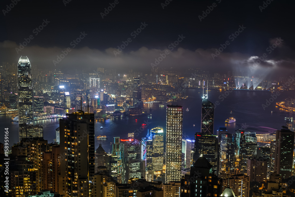 Aerial night view from Victoria peak to Kowloon bay and illuminated skyscrapers of Hong Kong island, China republic
