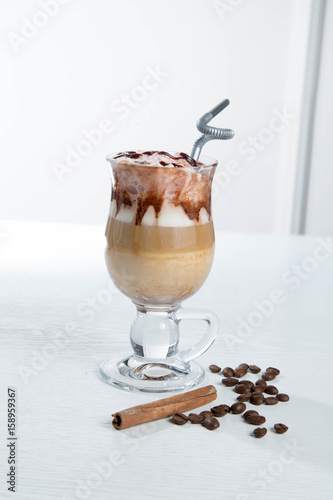 Glass of cold latte coffee topic cocolate cream on isolated white background with desserts