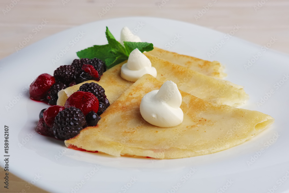 Portion on thin pancakes with sweet cream cheese and berries. Portion on thin pancakes with sweet cream cheese and berries.
