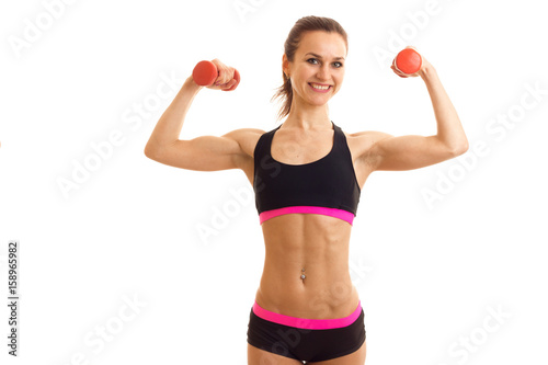 fun energetic athlete raised the dumbbells in your hands looks into the camera and laughs