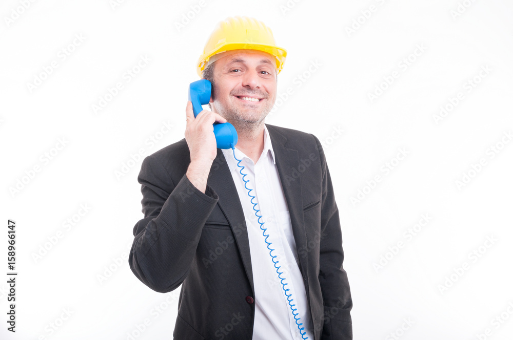 Portrait of architect talking on blue big telephone receiver Portrait of architect talking on blue big telephone receiver