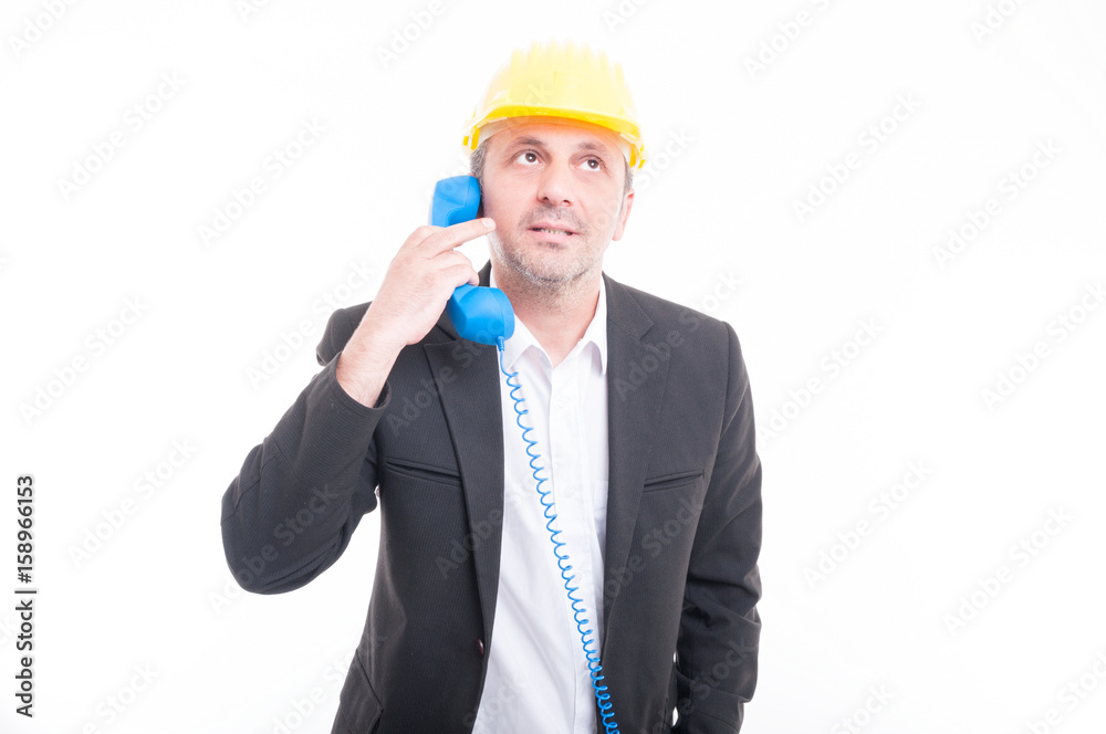 Portrait of architect talking on blue big telephone receiver Portrait of architect talking on blue big telephone receiver