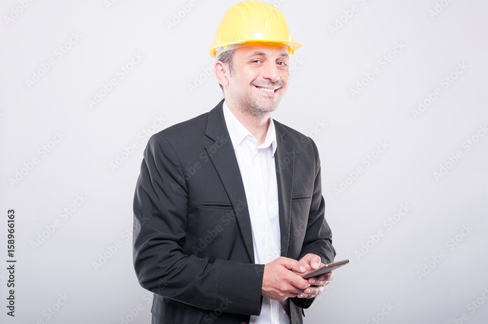 Portrait of architect smiling and texting on smartphone Portrait of architect smiling and texting on smartphone