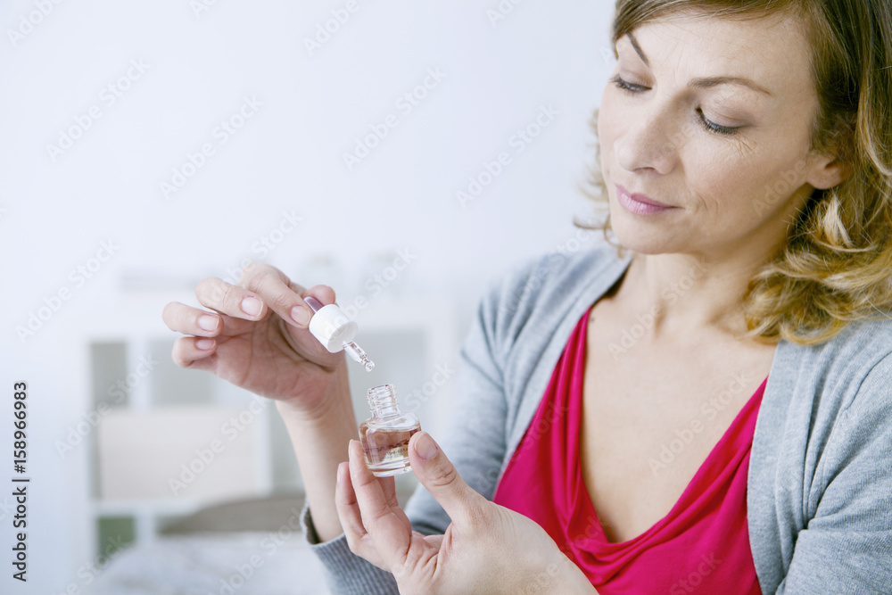Woman using essential oil Woman using essential oil