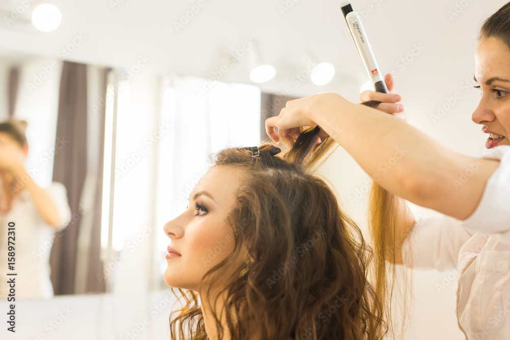 Fototapeta premium Hairdresser doing haircut for women in hairdressing salon. Concept of fashion and beauty. Positive emotion.