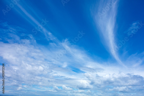 Blue sky background with white fluffy clouds.