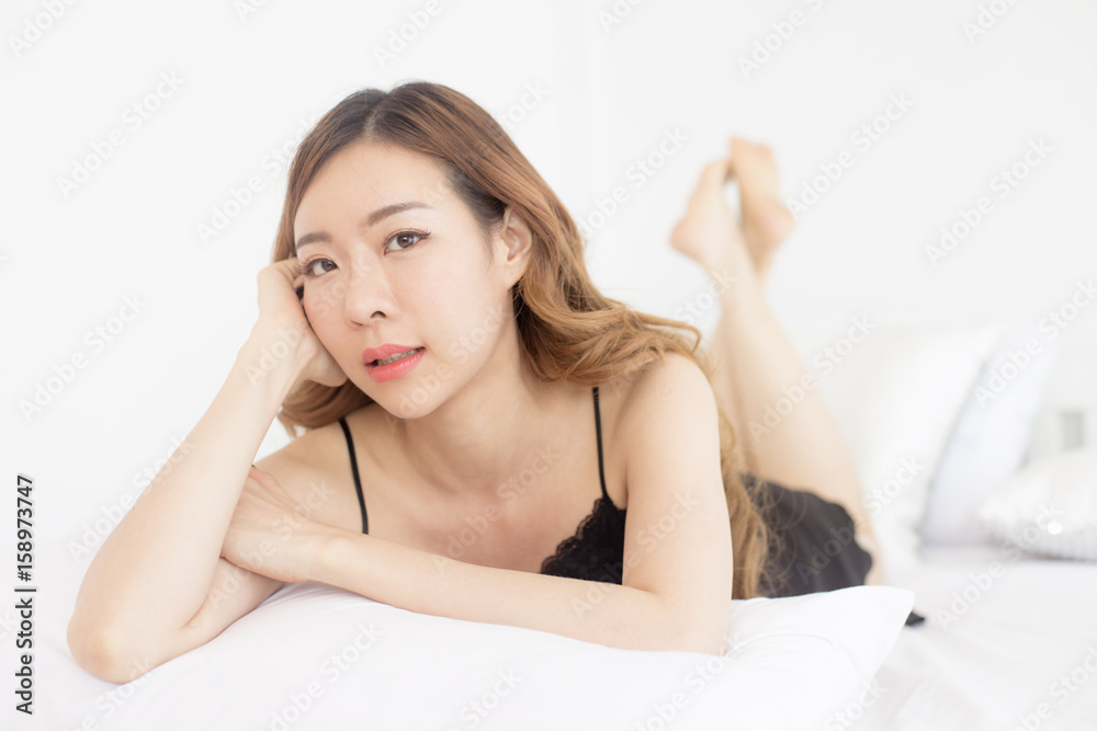Beautiful young asian woman looking camera while waking up on the bed, woman sexy in bedroom concept, 20s year old. Beautiful young asian woman looking camera while waking up on the bed, woman sexy in bedroom concept, 20s year old.