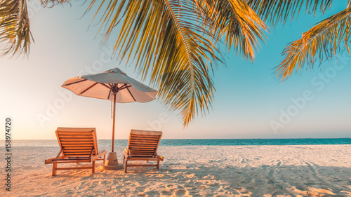 Beautiful beach. Chairs on the sandy beach near the sea. Summer holiday and vacation concept. Inspirational tropical beach. Tranquil scenery, relaxing beach, tropical landscape design. Moody landscape