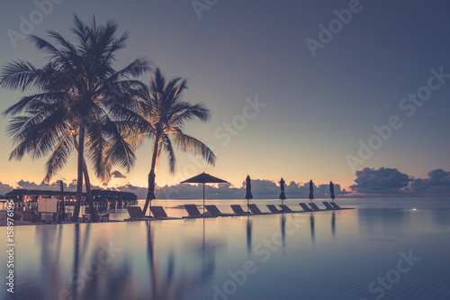 Luxury poolside on the beach with sunset colors. Amazing luxury summer background © icemanphotos