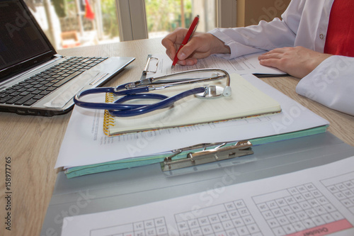 Doctor sitting at the desk near window. Medicine doctor's working table