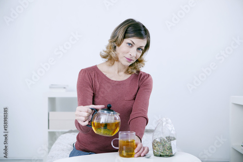 Fotografía Woman pouring herbal tea