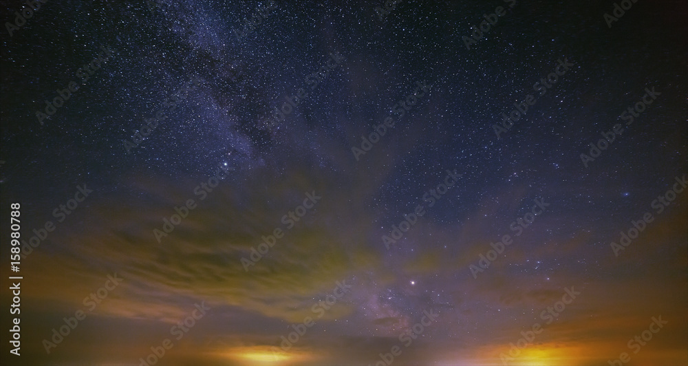 The stars of the Milky Way with clouds in the night sky.