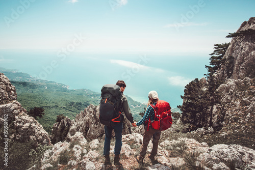 Couple travelers Man and Woman holding hands enjoying mountains aerial view Love and Travel Lifestyle concept. Young family traveling together active adventure vacations