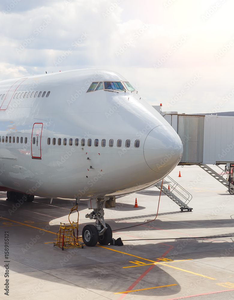 Close-up of very large wide-body airplane being prepared for towing, with tow-truck connected. Close-up of very large wide-body airplane being prepared for towing, with tow-truck connected.