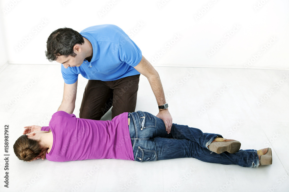 First aid techniques placing the victim in the recovery position Step