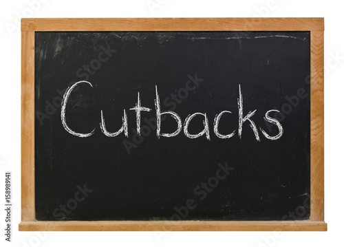 Cutbacks written in white chalk on a black chalkboard isolated on white