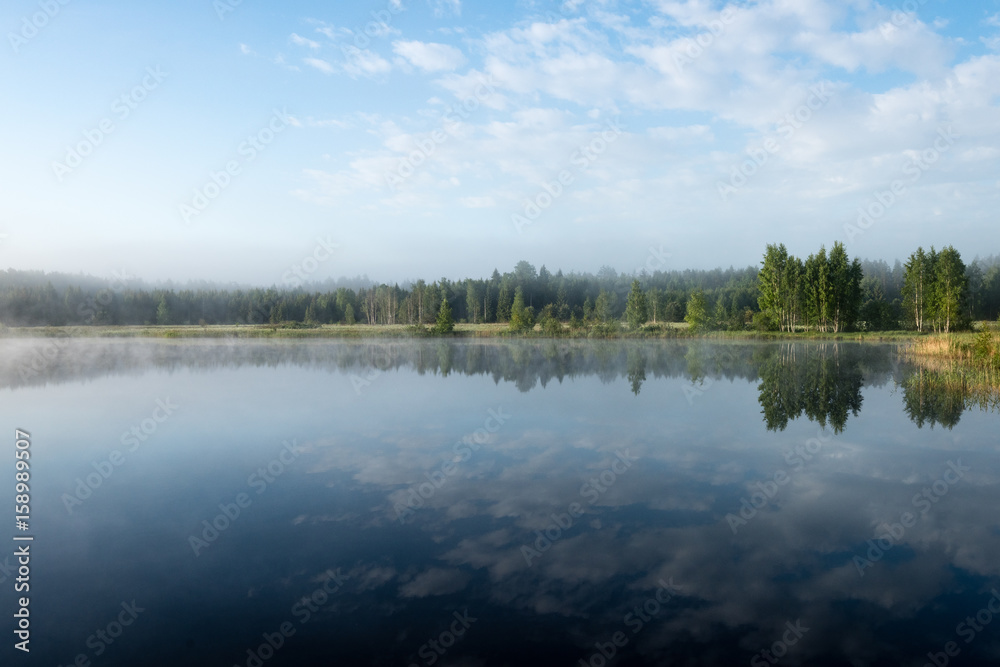 reflections in the lake water in the morning mist