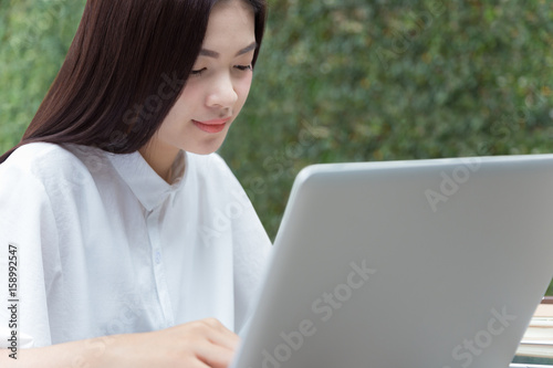 attractive asian woman working on her computer outdoor