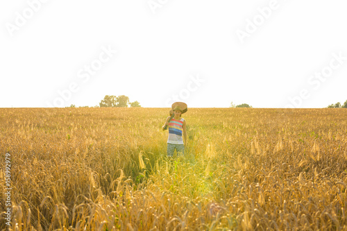 Young hipster man holding a guitar with a walking in nature, Relaxing in the field in a sunny day.