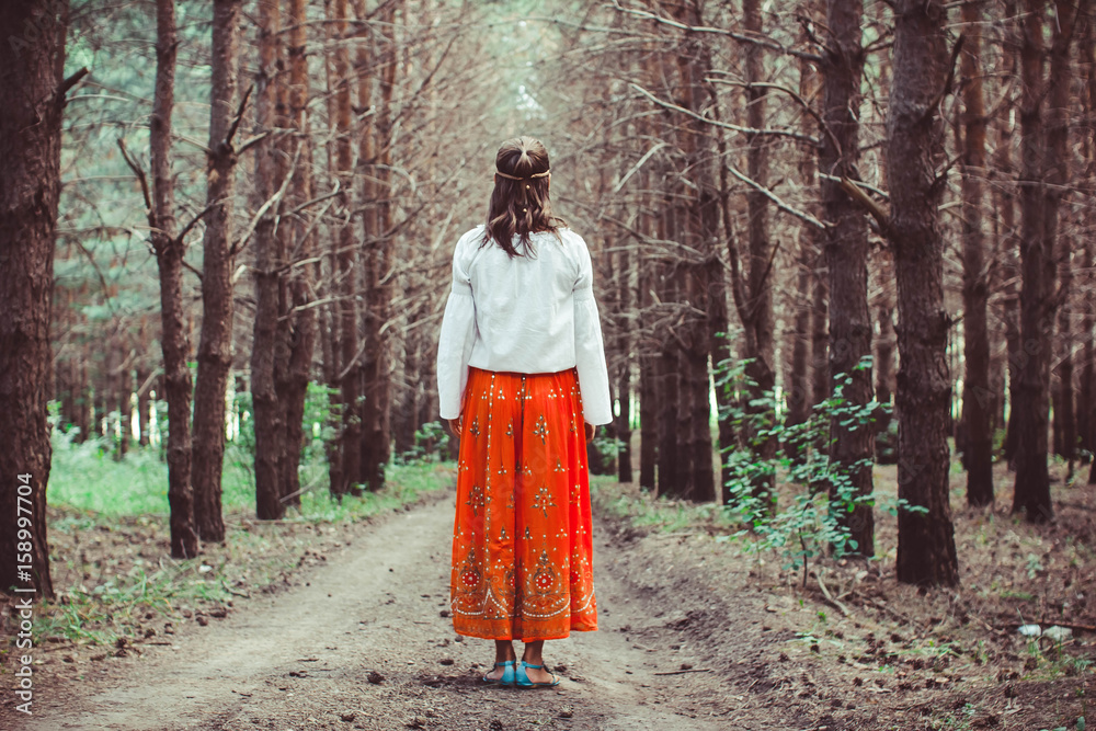 A woman is standing between trees A woman is standing between trees