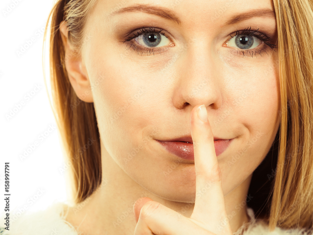 Young blonde woman making silence gesture Young blonde woman making silence gesture