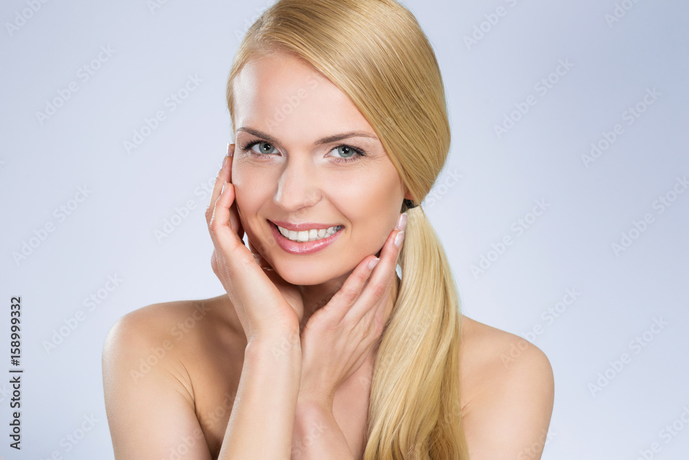 Young beautiful woman with hands on cheeks smiling Young beautiful woman with hands on cheeks smiling