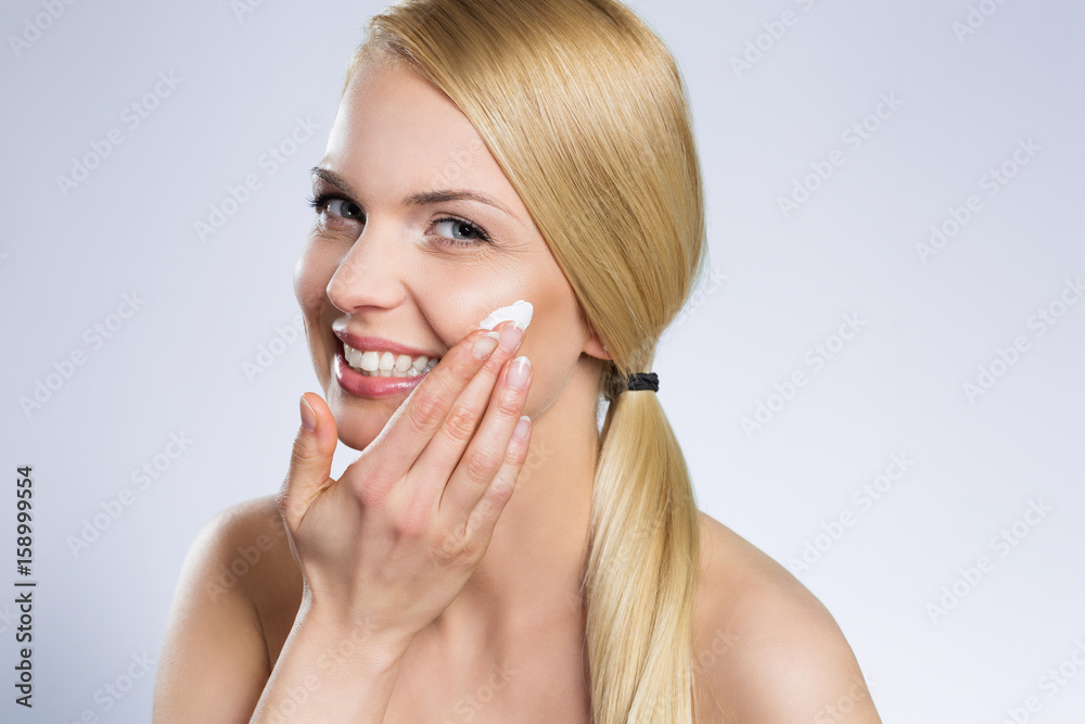 Εκτύπωση καμβά Beautiful happy woman applying cream on face
