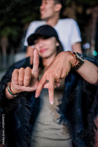 Portrait of young woman making LA hand gesture outside Los Angeles County Museum of Art at night photo