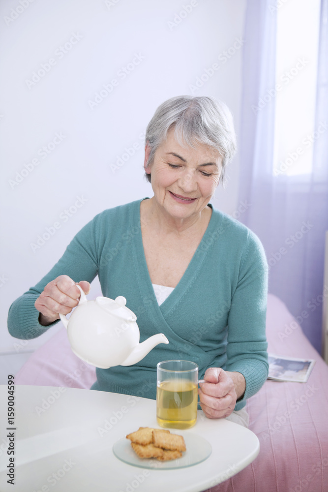 Senior woman pouring tea