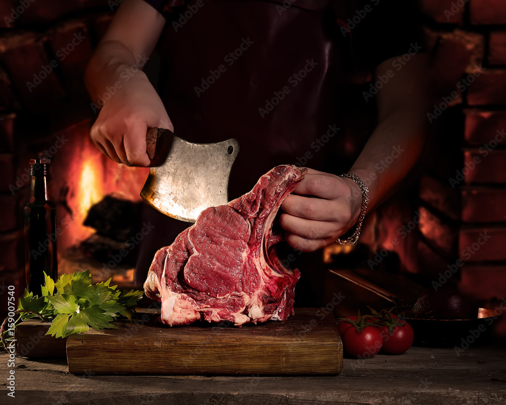 Man cutting raw beef meat.