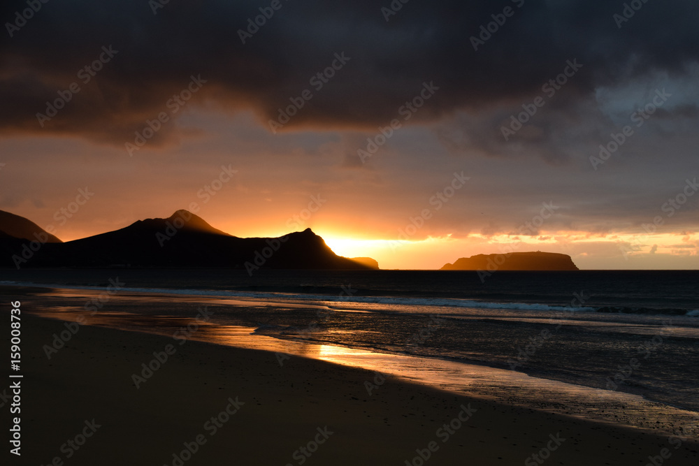 Sunrise over headland and the Atlantic Ocean from the beach at Porto Santo Island, Madeira, Portugal Sunrise over headland and the Atlantic Ocean from the beach at Porto Santo Island, Madeira, Portugal