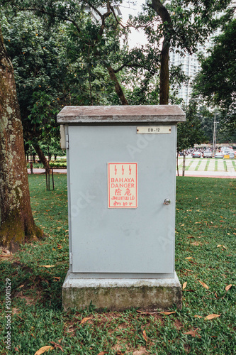 Outdoor electric box with many languages words near Petronas twin towers in Kuala Lumpur, Malaysia.