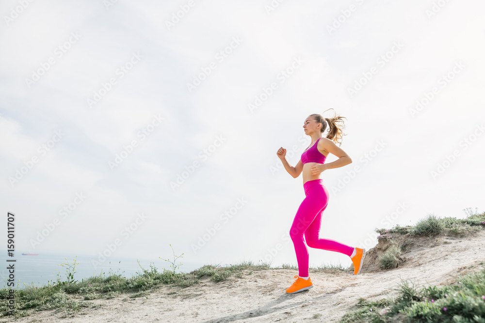 Young fitness girl running in outdoors. Sporty woman