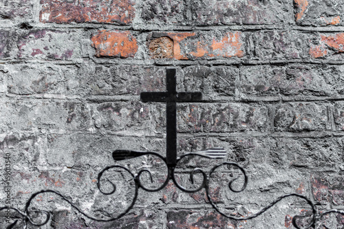 Cross on brick wall background