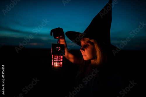 child with hat of halloween and light in the hands  photo