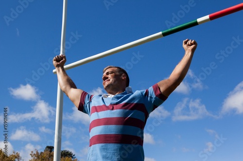 Low angle view of smiling rugby player with arms 
