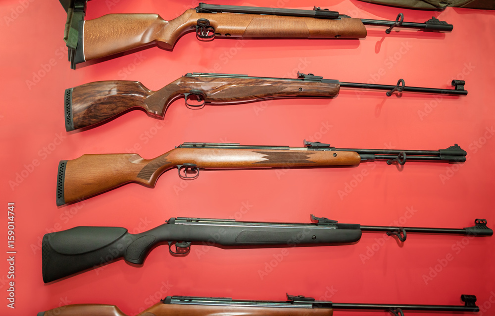 Different types of rifles on the red wall
