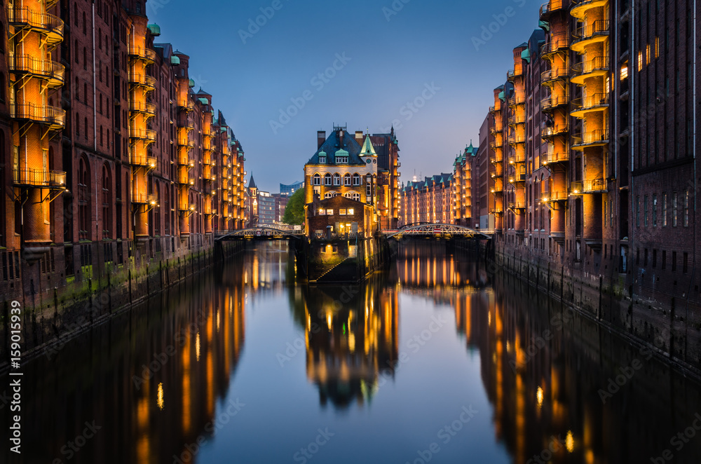Old Warehouses District in Hamburg, Germany at Twilight with Clear Sky and Reflection in Water