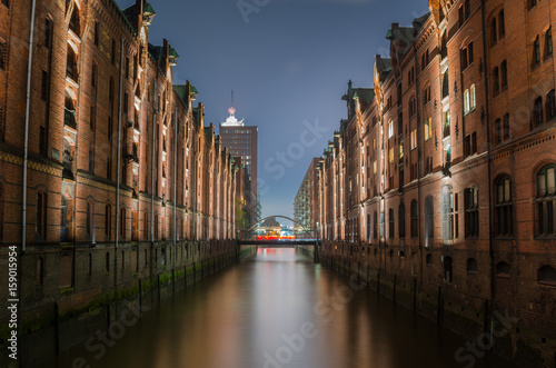 Historic Warehouse District in Hamburg, Germany, at Night. Reflection in Water. © alpegor