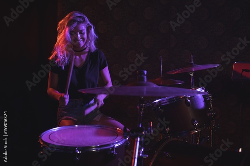 Female drummer performing on stage in nightclub