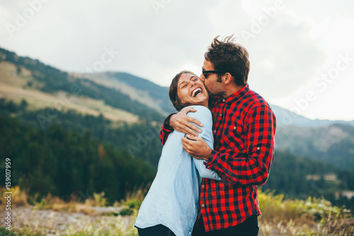 Kissing lovely couple on a beautiful mountain landscape