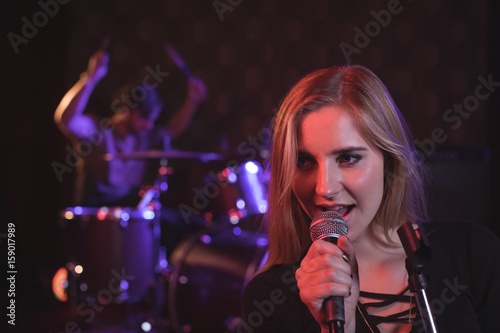 Close up of female singer performing with male drummer 
