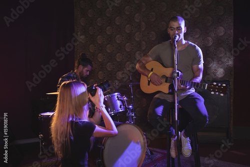 Woman photographing male performer in nightclub