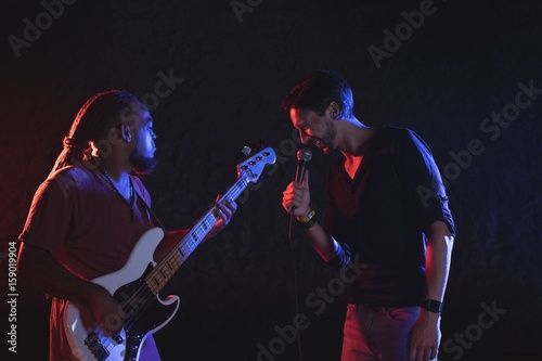 Male singer with guitarist performing at music concert