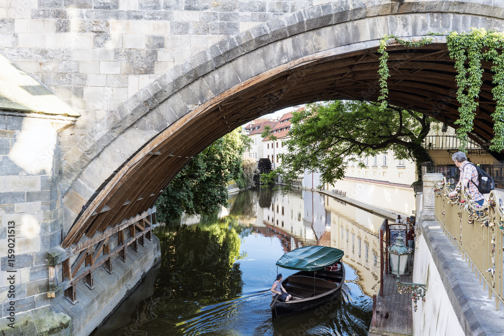  Canal of the Moldova river under the last arch of Charles Bridge, Prague.