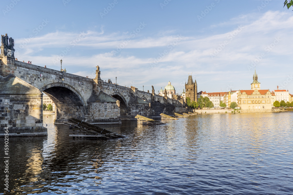 View of the Charles bridge and the Liechtenstein Palace on the Vltava river from the shore of Stare Mesto in Prague