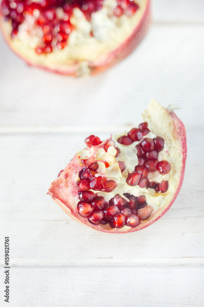 Parts of fresh pomegranate over white wooden surface. Parts of fresh pomegranate over white wooden surface.