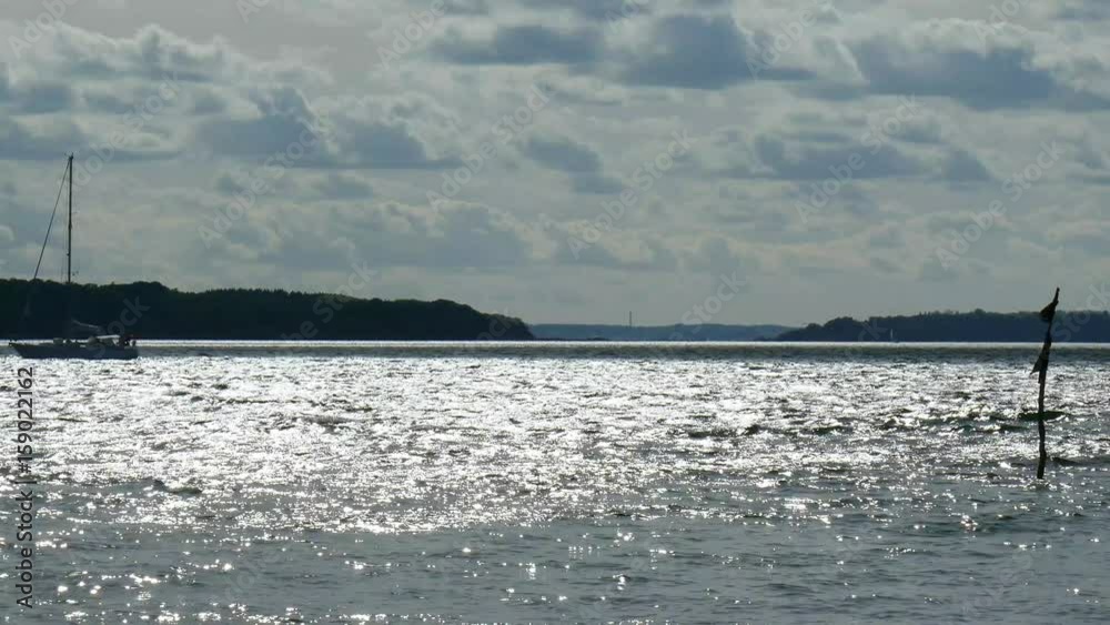 Sportboot unterwegs auf dem Meer. Glitzernde Wellen und interessante Wolkenformationen Sportboot unterwegs auf dem Meer. Glitzernde Wellen und interessante Wolkenformationen