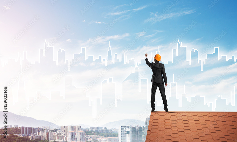 Man architect draw silhouette of modern city on blue sky. Mixed media Man architect draw silhouette of modern city on blue sky. Mixed media