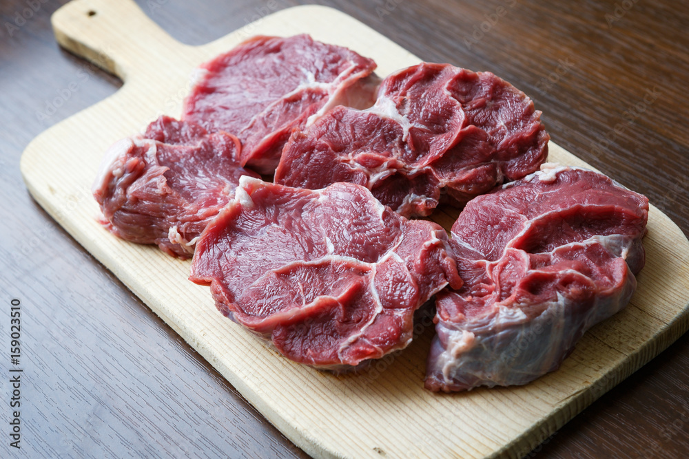 Fresh raw beef on wooden cutting plate